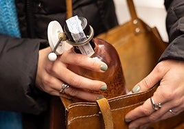 Una mujer comprando una botella de alcohol.