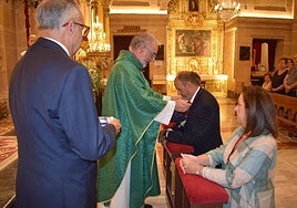 El rector de la basílica, Emilio Sánchez, en el momento de imponer la Cruz de Caravaca a Reinón