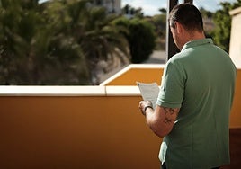 Uno de los afectados por los retrasos consultando papeles.