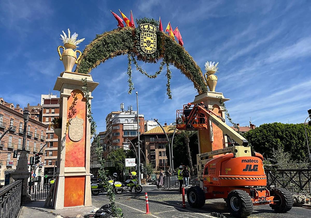 Trabajos de instalación de las decoraciones florales en el arco del Puente de los Peligros, este martes.