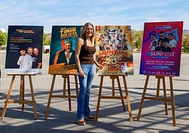 La concejala de Festejos ante los carteles de los artistas que actuarán con entrada gratuita en la feria.
