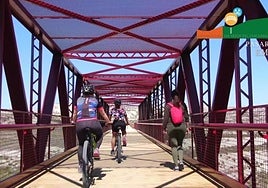 Varios ciclistas circulan por un puente en la vía verde del Chicharra.