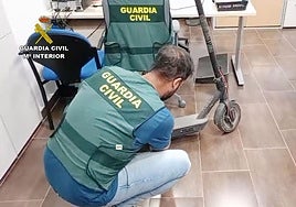 Un agente examina uno de los patinetes recuperados.