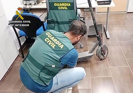 Un agente examina uno de los patinetes recuperados.