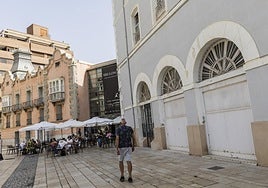 Un hombre pasea frente a las antiguas cocheras del Gobierno Militar, en la plaza del Ayuntamiento.
