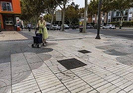 Una mujer camina por el paseo con la ayuda de su andador, rodeada de los desperfectos que hay en las aceras de esta céntrica calle.