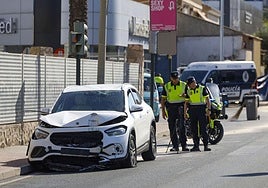 Dos agentes de la Policía Local observan el vehículo del conductor ebrio que atropelló mortalmente a una mujer el miércoles en la carretera de Alicante.