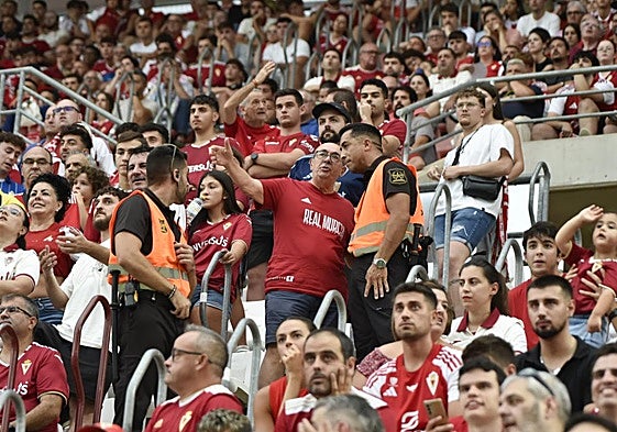 Un aficionado dialoga con dos miembros de seguridad del club durante el Murcia-Torremolinos.