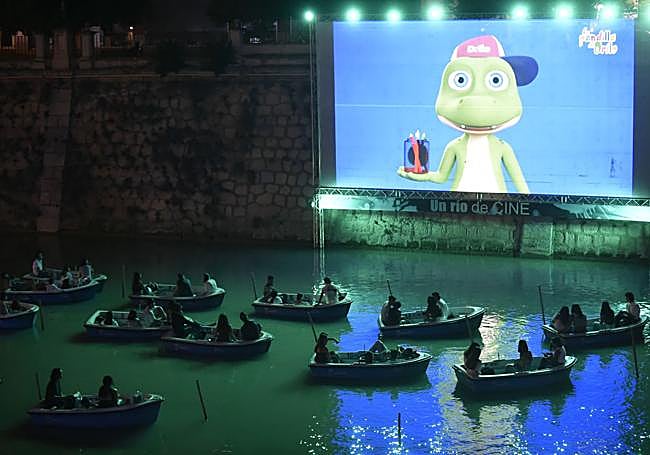 Espectadores disfrutan anoche, sentados en barcas, de 'El libro de la selva'.