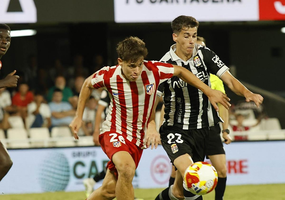 Núcleo duro. Jano Monserrate, jugador del Atlético Madrileño, persigue un balón ante Nacho Sánchez, del FC Cartagena.