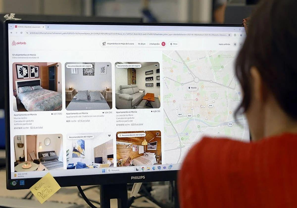 Una mujer repasa ofertas de alojamientos turísticos de Airbnb en Murcia.