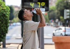 Un joven se refresca en la calle en plena ola de calor en Murcia.