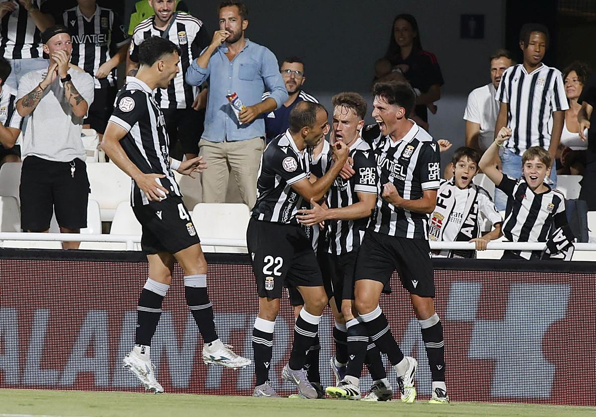 Los jugadores del Cartagena celebran uno de los goles ante el Atlético Madrileño con varios aficionados detrás.