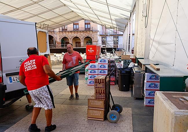 Hosteleros preparan las barras debajo de la carpa en la plaza de España para la feria de mediodía.