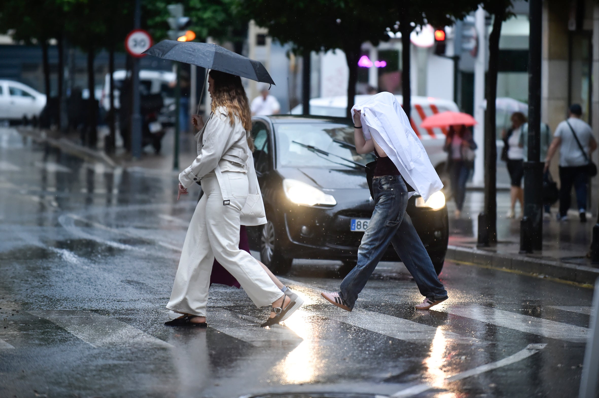 Dos viandantes bajo la lluvia en la Gran Vía de Murcia, en una imagen de archivo.
