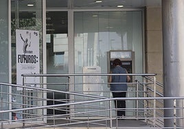 Una mujer sacando dinero de un cajero automático, en una imagen de archivo.