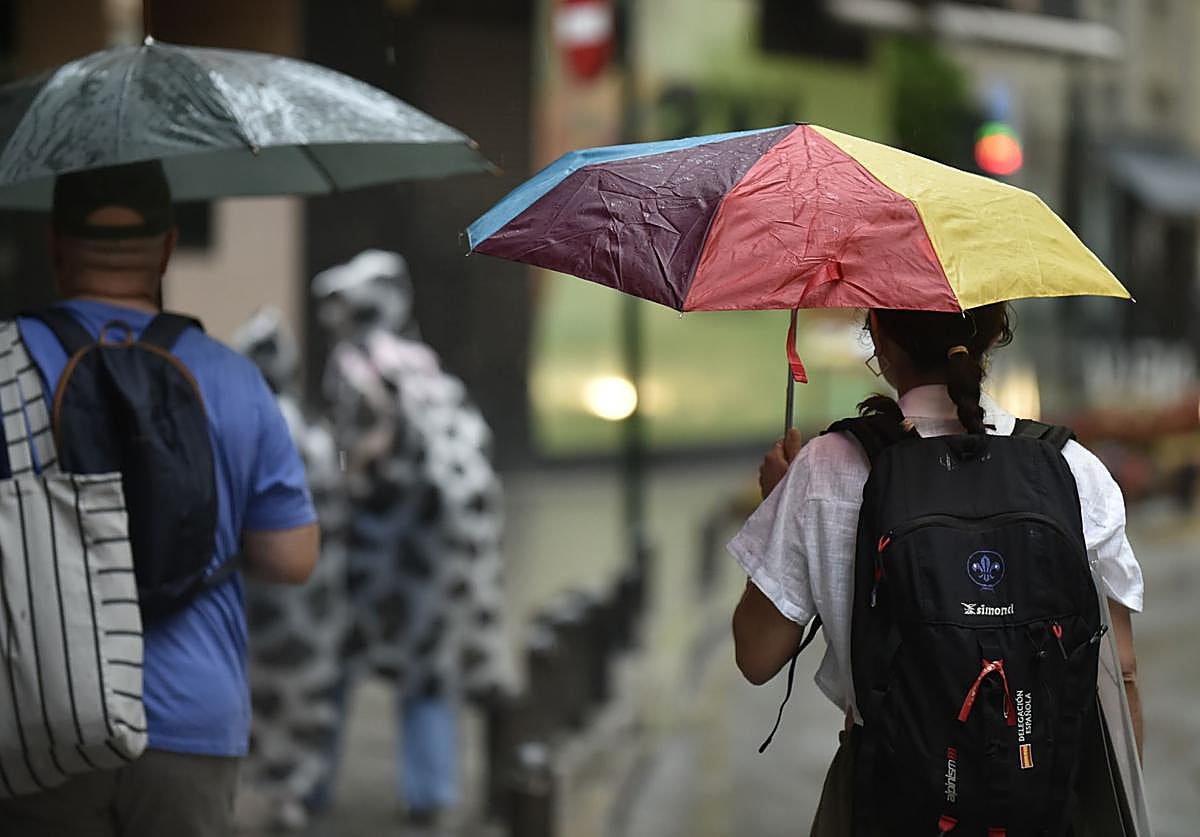 Dos personas pasean con paraguas por Murcia en un día de lluvia.