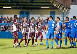 Jugadores del Xerez y del Águilas se posicionan en el área antes de la salida de un córner.