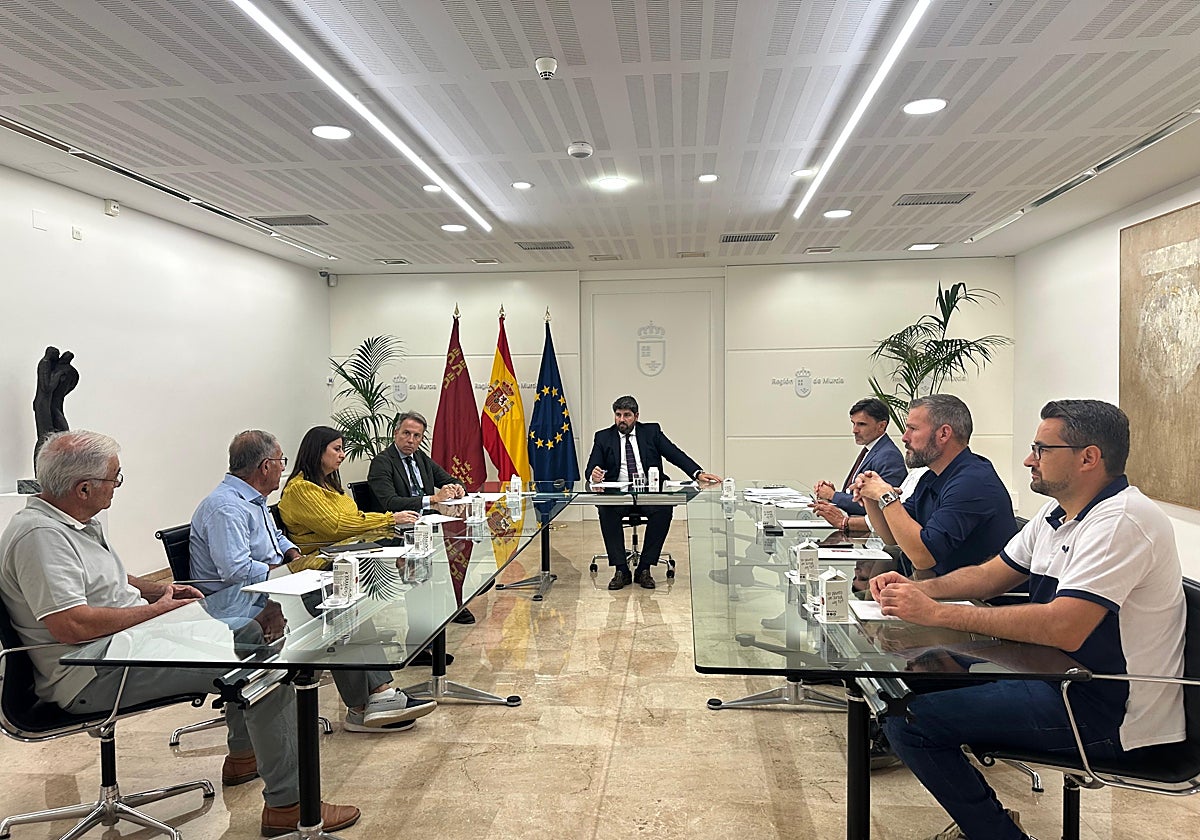 López Miras (c) durante la reunión con vecinos afectados por las riadas, el alcalde y concejales.
