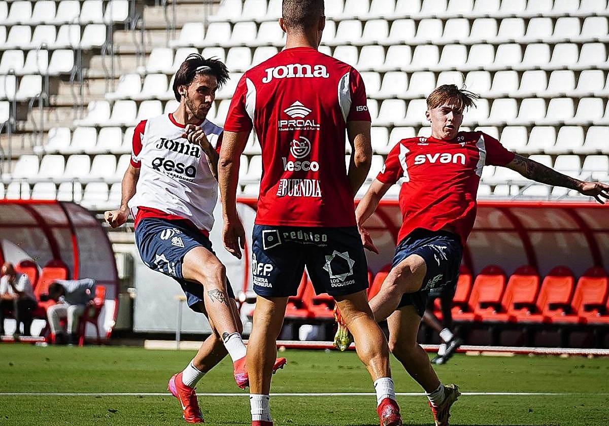 Andrés y Sarabia, bajo la mirada de Alberto, en un lance de un entrenamiento del Real Murcia.