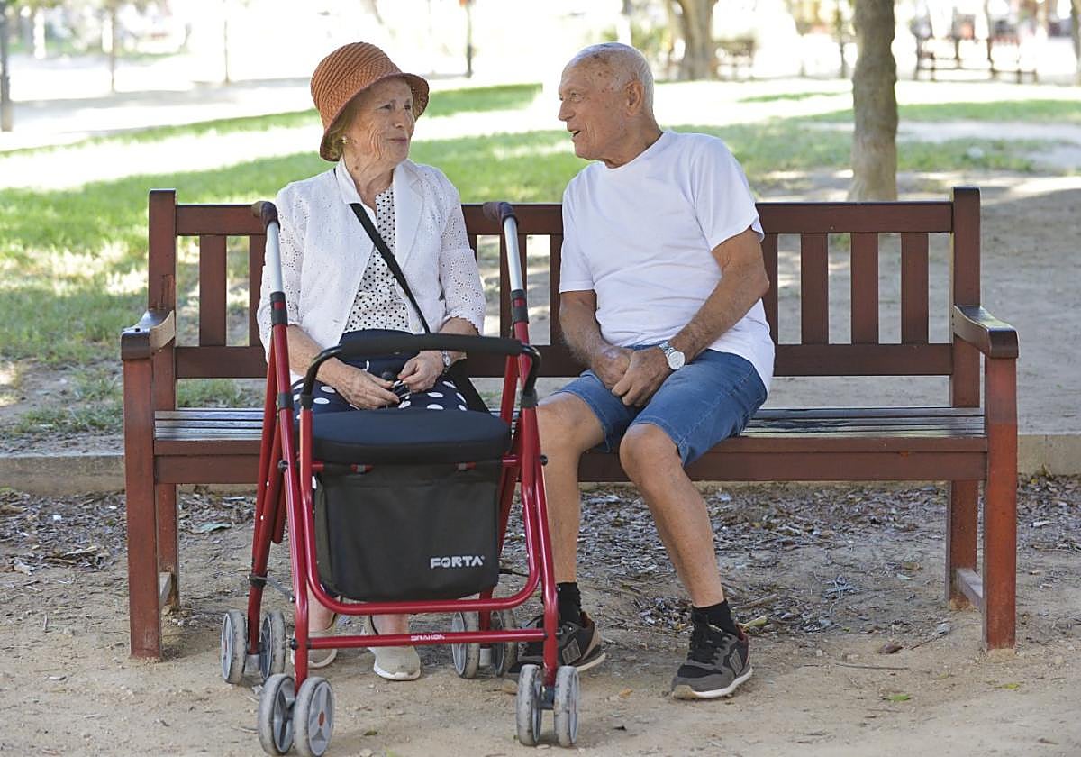 Rosario Sánchez, vecina de Santiago el Mayor, con el andador con asiento que le recomendó hace casi dos años su doctora y, junto a ella, su marido, Lorenzo Navarro.