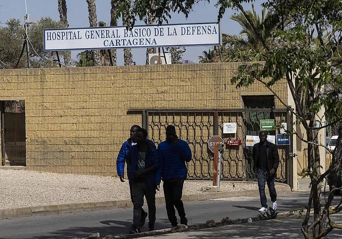 Cuatro inmigrantes salen del campamento del Hospital Naval, en una imagen de archivo.