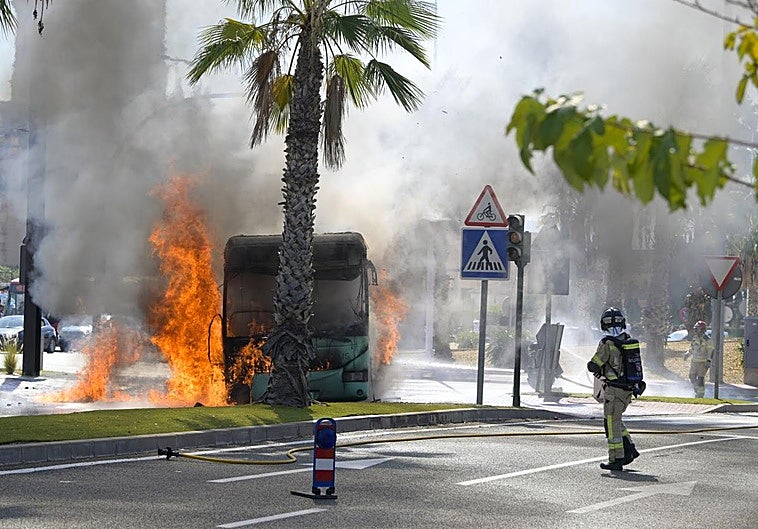El autobús, ardiendo, en la rotonda de entrada a la UCAM, en Murcia.
