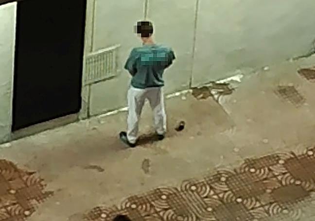 Un joven orina en el lateral de la galería comercial.