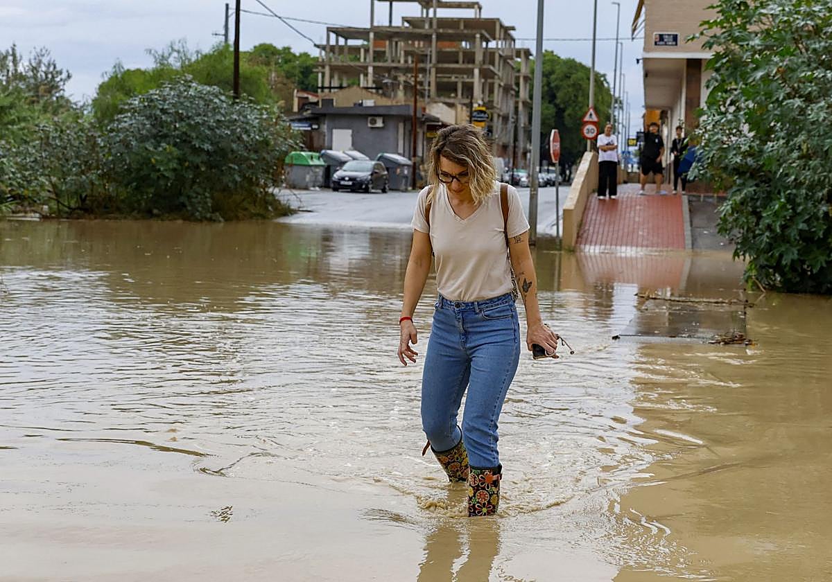 Una mujer atraviesa la rambla del Secano, en la pedanía murciana de Torreagüera.