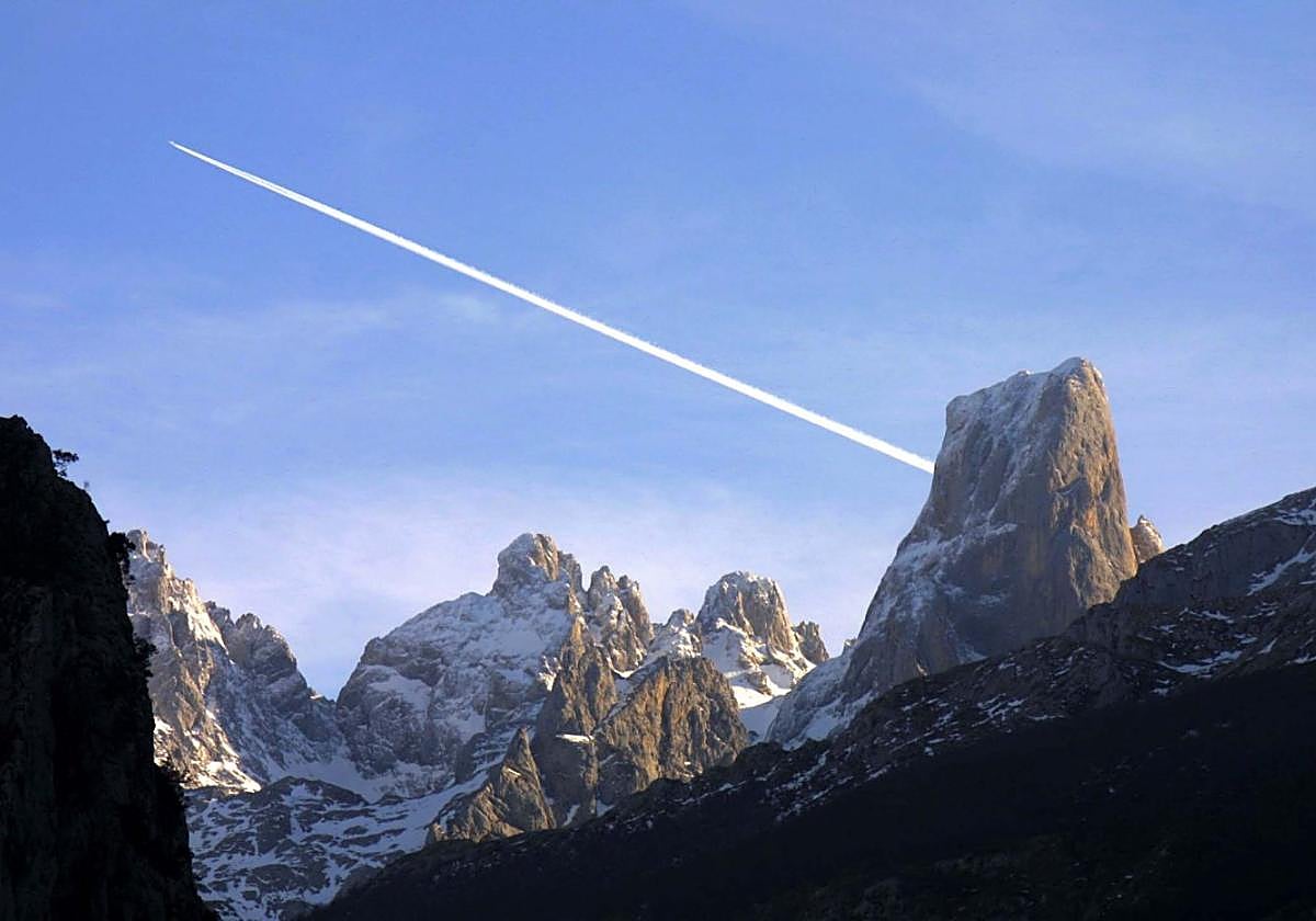 La estela que deja un avión reactor que sobrevuela los Picos de Europa parece salir del mismo Naranjo de Bulnes.