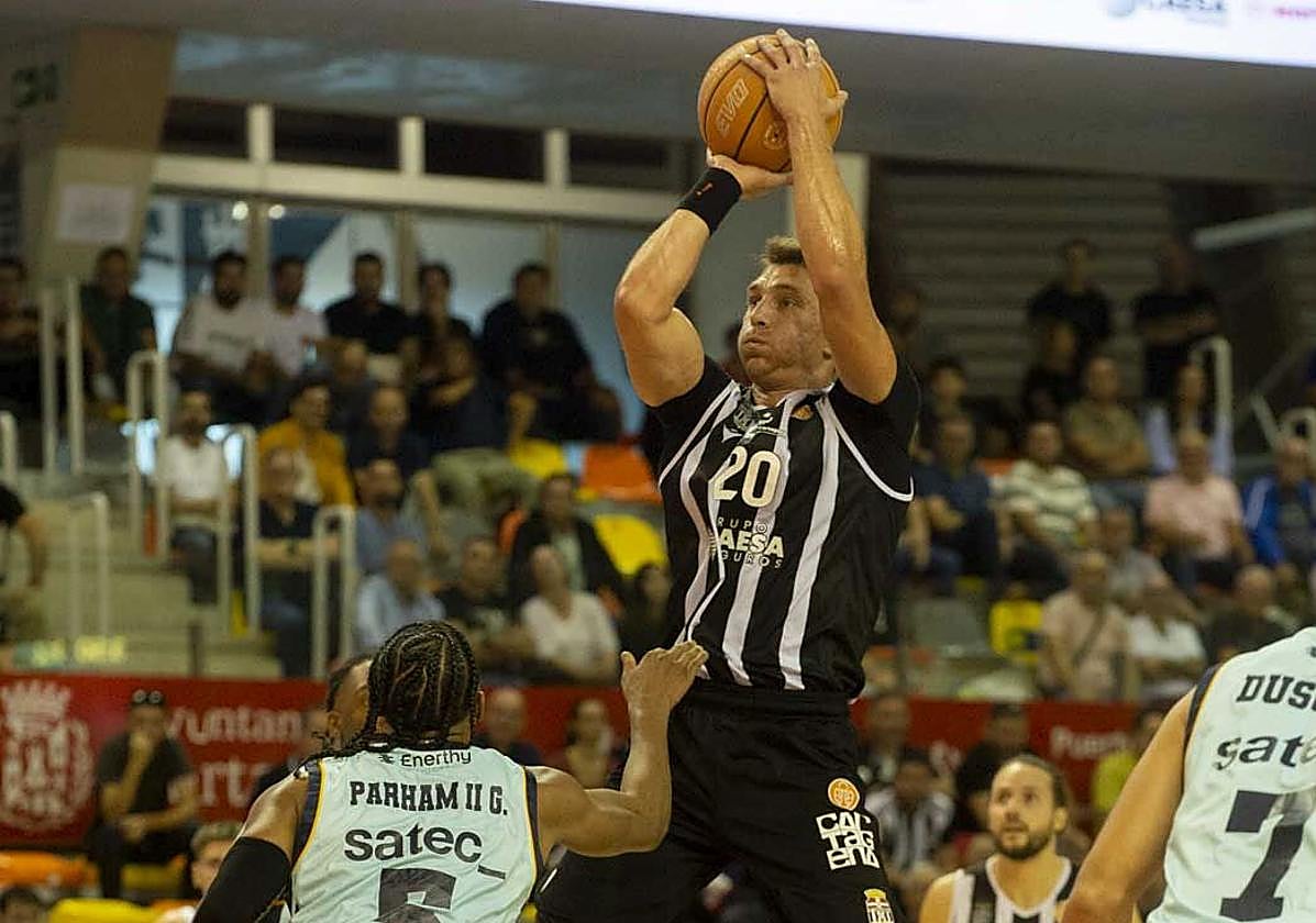 El estadounidense con pasaporte checo Spencer Svejcar lanza a la canasta rodeado de rivales.