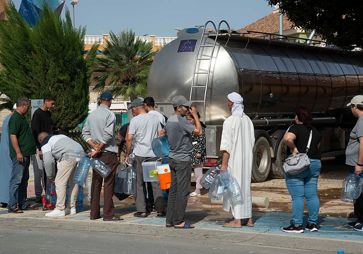 Varios vecinos de Roldán hacen cola, este domingo, para llenar las garrafas de agua de un camión cisterna.