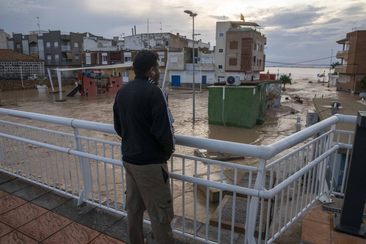 Un joven mira el paseo marítimo de Los Alcázares anegado.