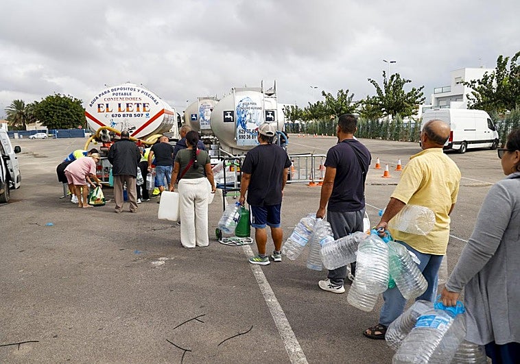 Vecinos de San Pedro del Pinatar, con botellas ante un camión cisterna.