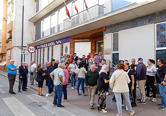 Vecinos congregados ante el centro cívico donde se encuentra el cuartelillo de la Policía Local, ahora cerrado.