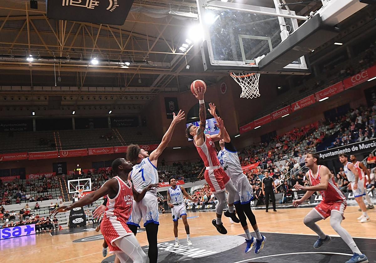 Jonah Radebaugh intenta una entrada a canasta con tráfico en la zona, mientas sus compañeros Moussa Diagne y Will Falk ya se posicionan para el posible rebote ofensivo.