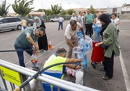 Vecinos del Mar Menor hacen cola para llenar sus garrafas de agua.