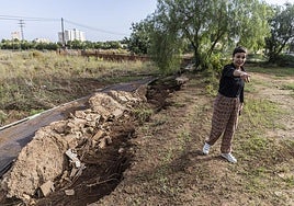 Virginia Bernal, junto a la valla arrancada por el agua.