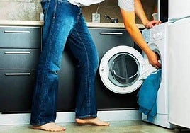 Imagen de archivo de una persona poniendo una lavadora.