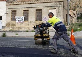 Un operario remata el asfaltado de uno de los baches de la zona.