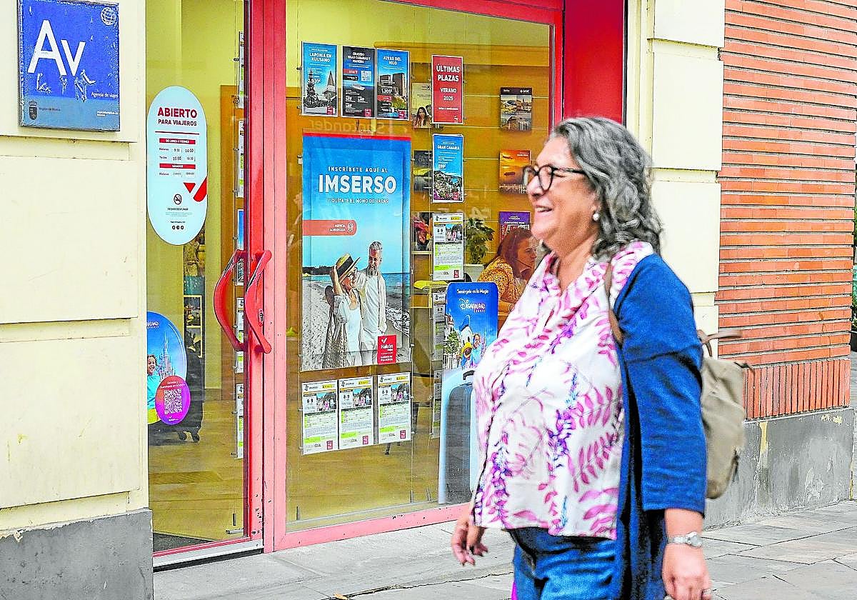 Una mujer pasa junto a la oficina de una agencia de viajes en la Plaza Circular de Murcia, ayer, con el cartel del Imserso en el escaparate.