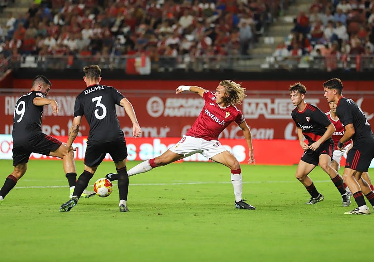 Pedro Benito, delantero del Real Murcia, intenta controlar un balón rodeado de cuatro jugadores del Sevilla Atlético en el estadio Enrique Roca.