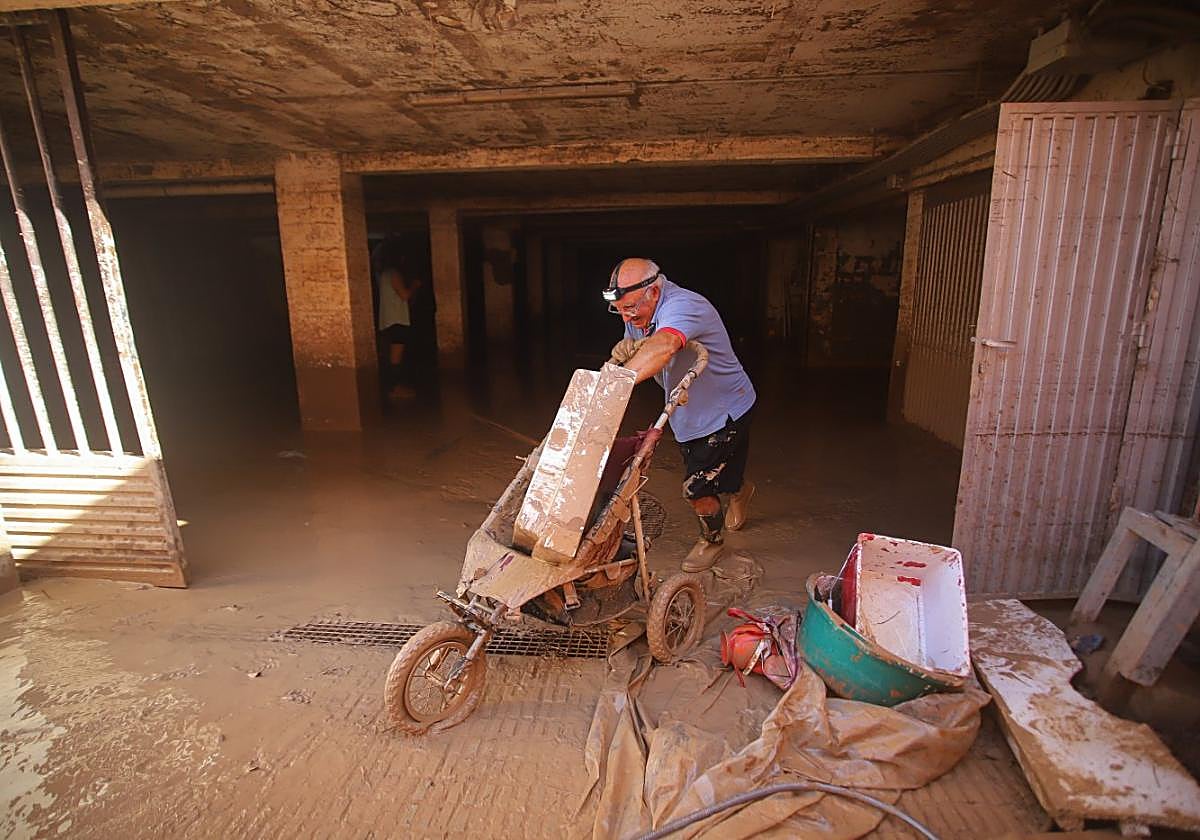 Un vecino sacando este sábado objetos de un trastero anegado de barro en la avenida Virgen de Loreto, en San Javier.