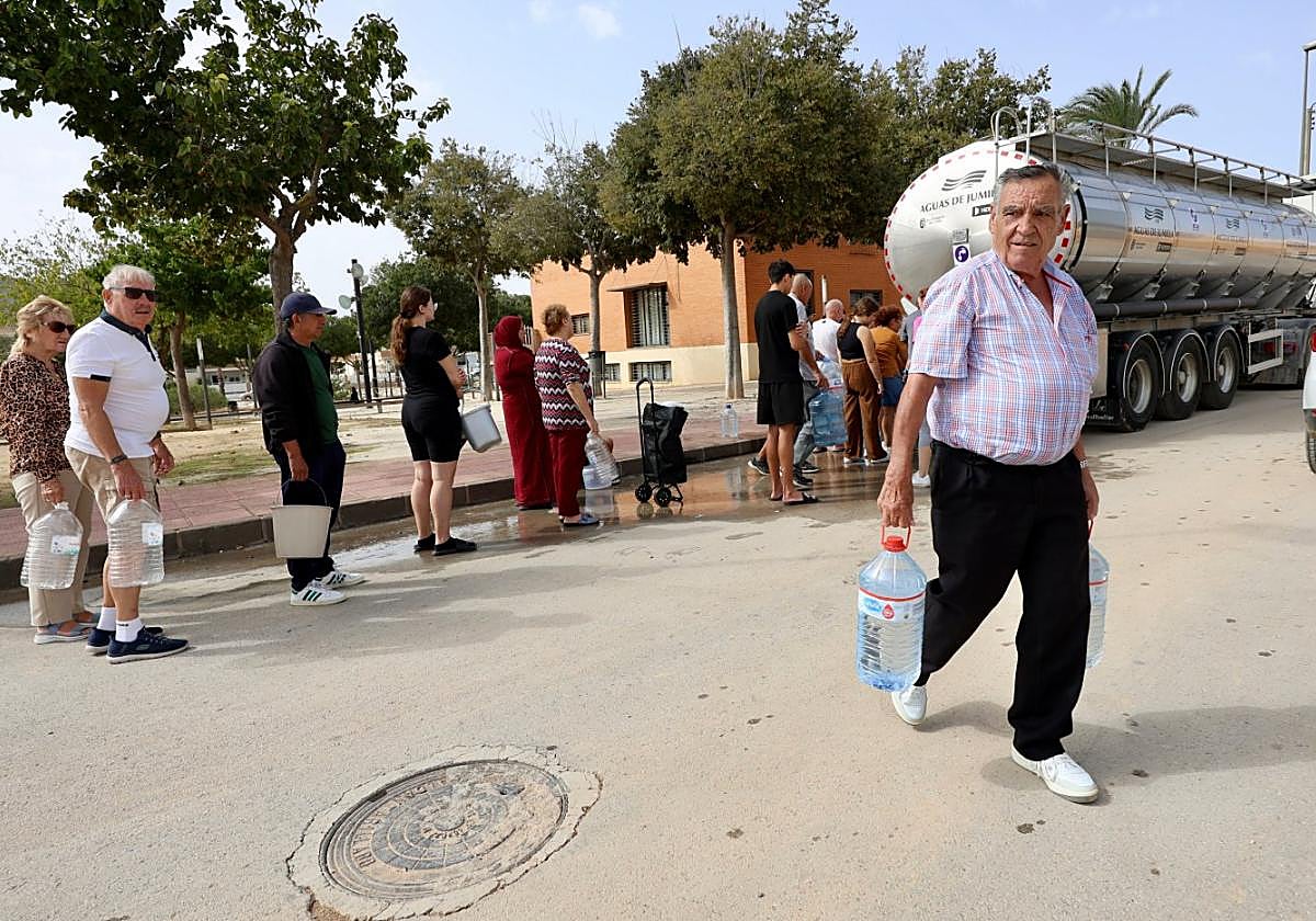 Vecinos de San Cayetano (Torre Pacheco) llenan garrafas de agua tras el corte de suministro.