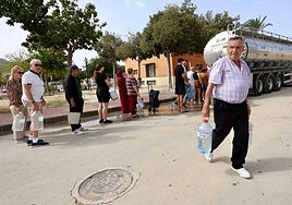 Un hombre con garrafas durante el corte de agua.