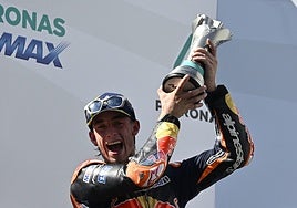 Acosta, segundo en el podio, muestra su trofeo.