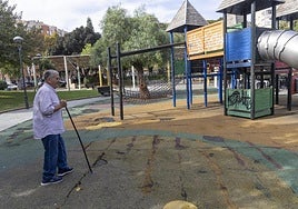 Un vecino pasea por la zona de columpios de los Juncos, con la alfombra de caucho repleta de agujeros y pintadas en los juegos.