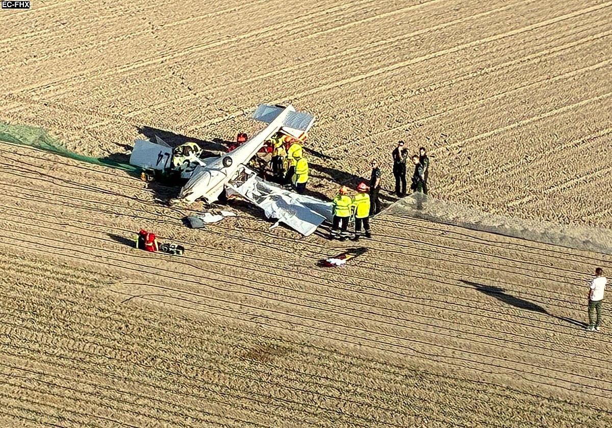 Efectivos de Emergencias y agentes de la Guardia Civil, junto a la avioneta siniestrada.
