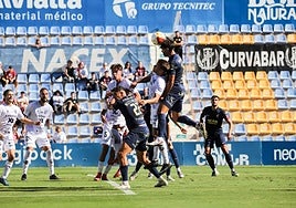 Jugadores del UCAM y el Yeclano pugnan por un balón tras una falta lateral.