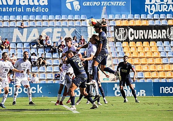 Jugadores del UCAM y el Yeclano pugnan por un balón tras una falta lateral.